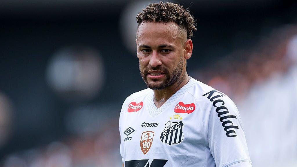- 香港Gameone娛樂城全新會員福利 - 入金00即返送00! Soccer player in a white jersey with a black club crest on the chest, looking off to the side during a match.