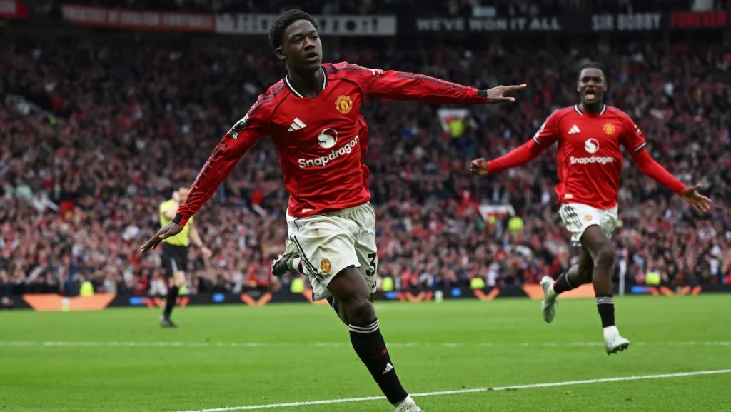 - 香港Gameone娛樂城全新會員福利 - 入金00即返送00! Two Manchester United players celebrate a goal on a packed stadium, foreground player mid-run with arms outstretched.