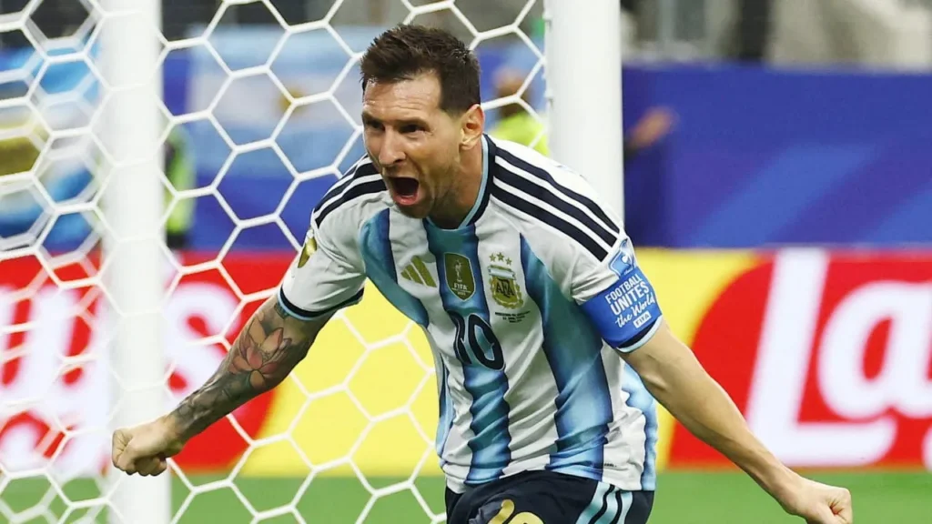 - 香港Gameone娛樂城全新會員福利 - 入金00即返送00! Male soccer player in an Argentina-style blue-and-white striped jersey celebrates a goal near the net.