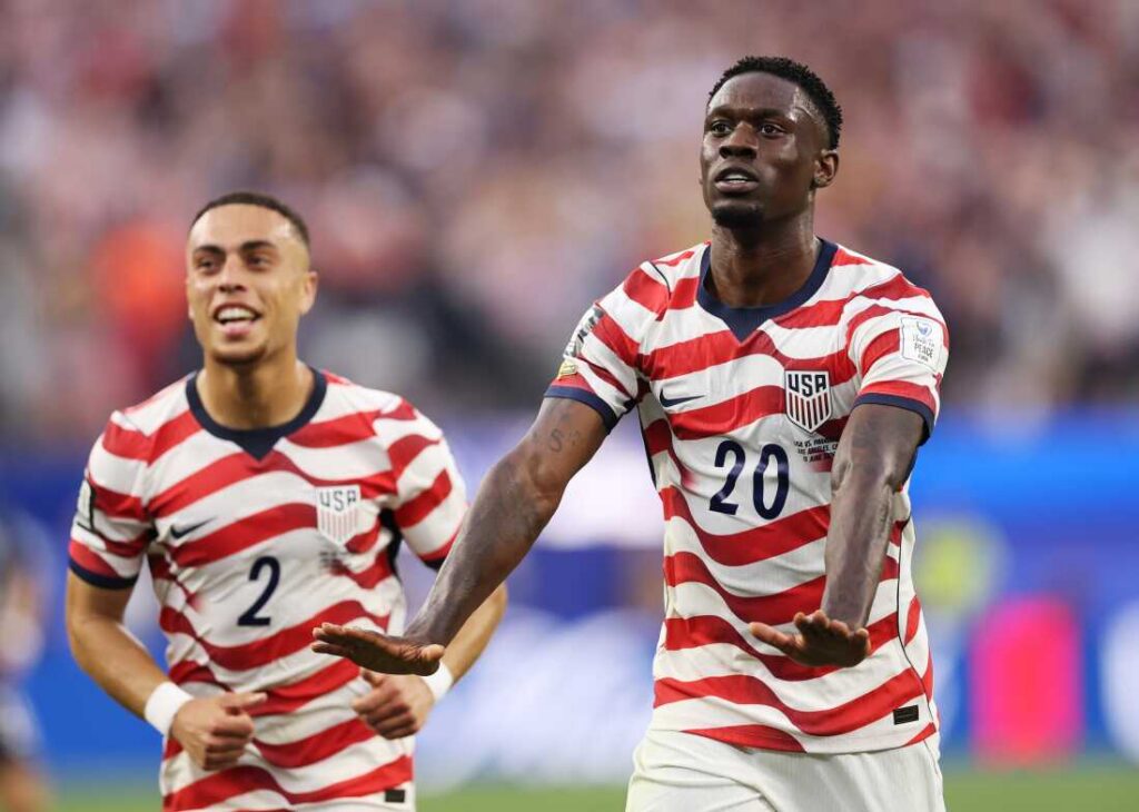 - 香港Gameone娛樂城全新會員福利 - 入金00即返送00! Two USA soccer players in red-and-white striped jerseys celebrate on the field.