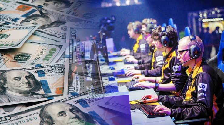 - 香港Gameone娛樂城全新會員福利 - 入金00即返送00! Competitive gamers in headsets compete at a tournament, with dollar bills in the background suggesting prize money/sponsorships.